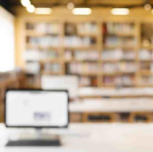 University library with computer and bookshelves, defocused